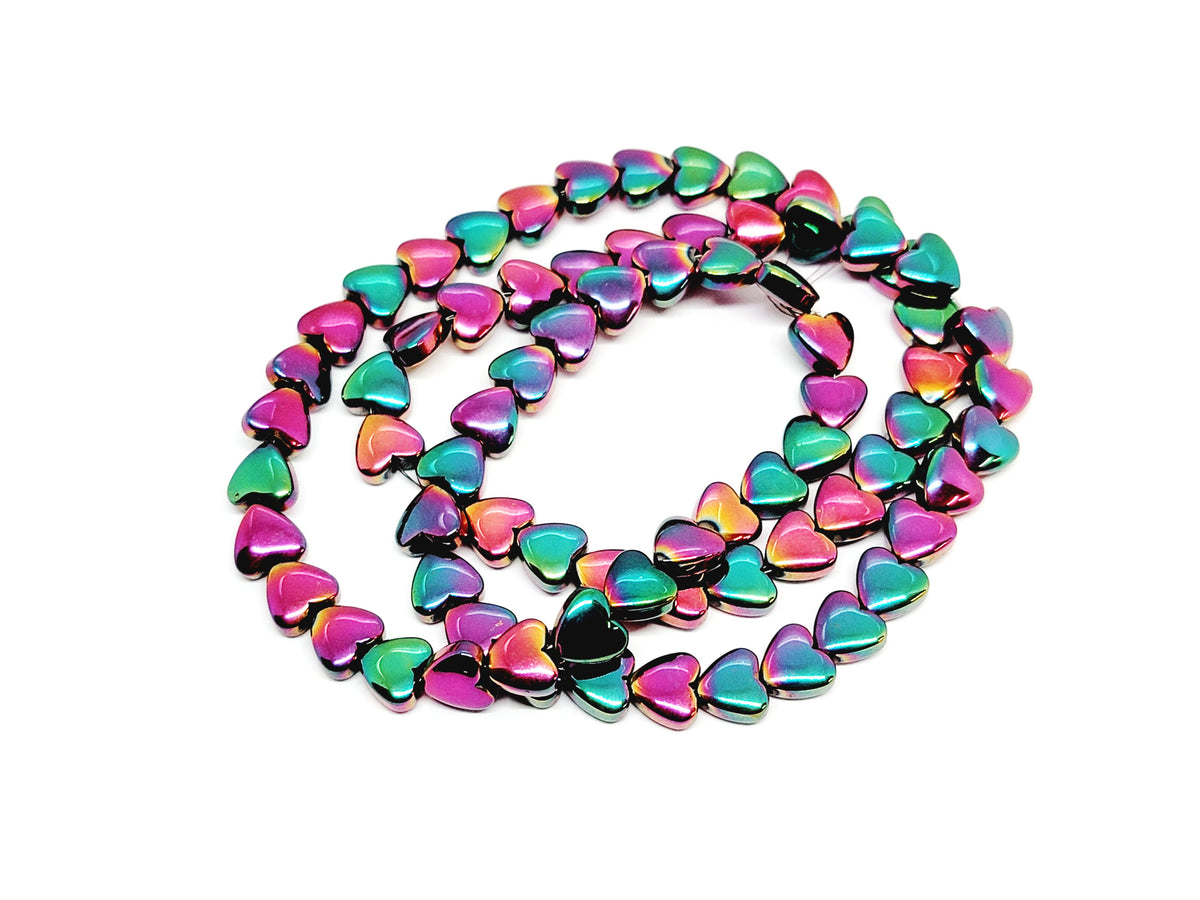 Strand of 6mm rose rainbow hematite heart beads coiled on a white background