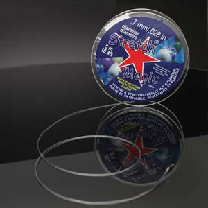 Stretch Magic clear cord spool with a loop of cord on a dark surface