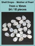 Mother of pearl teardrop pendants, 7 x 10mm, with a drill hole, on a dark background