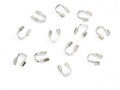 Scattered silver horseshoe-shaped wire guards on a white background