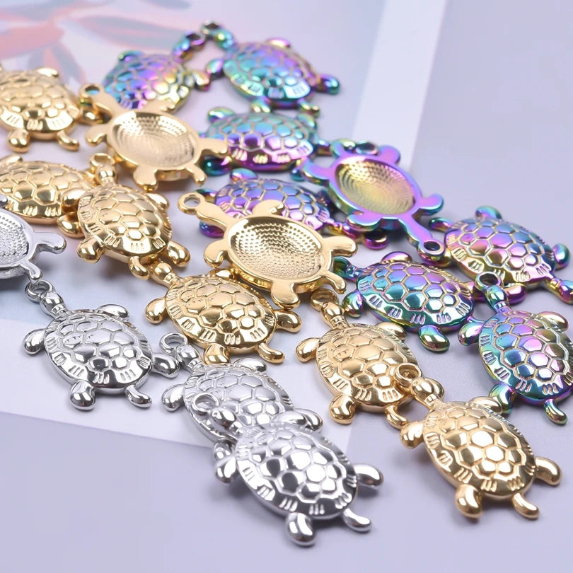 Pile of 25 x 14mm turtle charms in gold, silver and rainbow finishes