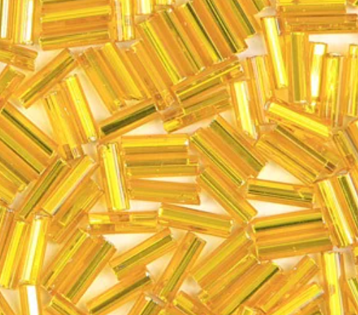 Close-up of loose 6mm Preciosa Czech glass bugle beads in silver-lined dark yellow