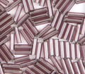 Close-up of loose 6mm Preciosa Czech glass bugle beads in silver-lined light amethyst