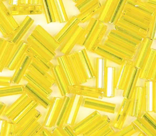 Close-up of loose 6mm Preciosa Czech glass bugle beads in silver-lined light yellow