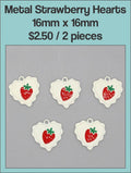 White enamel 16mm heart charms with a red strawberry design on a labelled product card