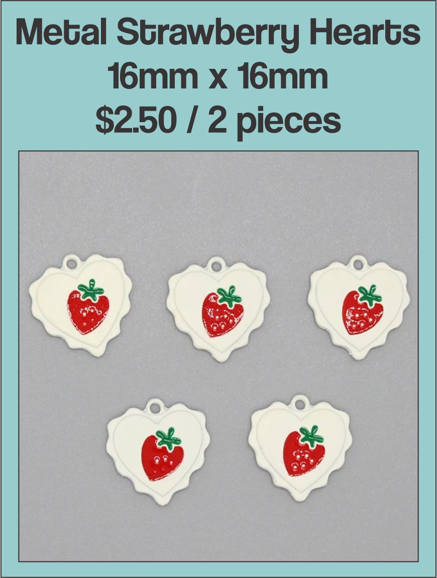 White enamel 16mm heart charms with a red strawberry design on a labelled product card