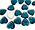 Pile of 20mm faceted teal resin heart gem cabochons (cabs), one flipped to show the flat back