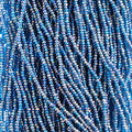 Close-up of strung Preciosa 13/0 true cut charlotte beads in transparent blue with an AB rainbow finish