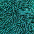 Close-up of strung Preciosa 13/0 true cut charlotte beads in transparent dark green with an AB rainbow finish