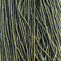 Close-up of strung Preciosa 13/0 true cut charlotte beads in transparent medium dark green