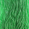 Close-up of strung Preciosa 13/0 true cut charlotte beads in transparent medium green