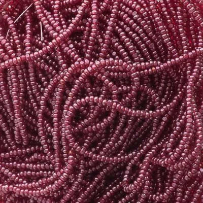 Close-up of strung Preciosa 13/0 true cut charlotte beads in transparent red with a luster finish