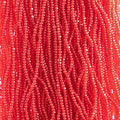 Close-up of strung Preciosa 13/0 true cut charlotte beads in transparent red