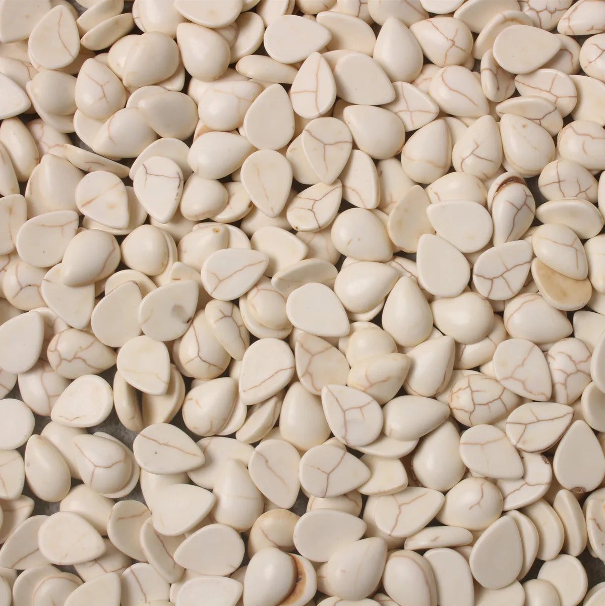 Pile of 10 x 14mm dyed howlite white drop cabochons (cabs) with natural veining