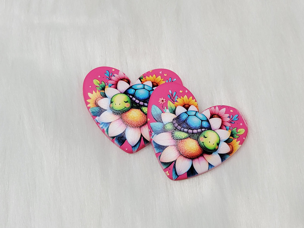 Pair of 37mm resin heart cabochons (cabs) in hot pink with a turquoise turtle on a large flower