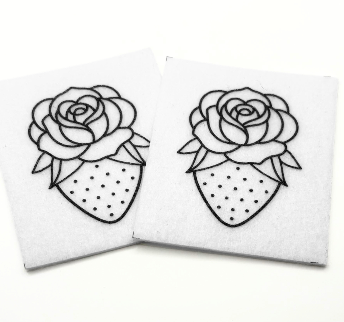 Two beading patterns printed in black on stiff white pellon squares, showing a strawberry with a rose