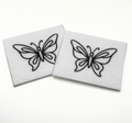 Two beading patterns printed in black on stiff white pellon squares, showing a detailed butterfly