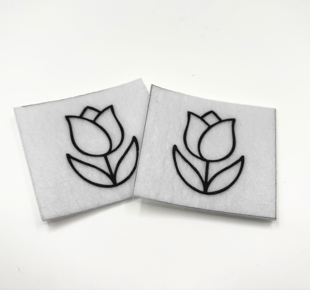 Two beading patterns printed in black on stiff white pellon squares, showing a tulip