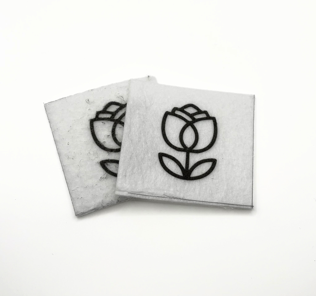 Two beading patterns printed in black on stiff white pellon squares, showing a tulip with leaves