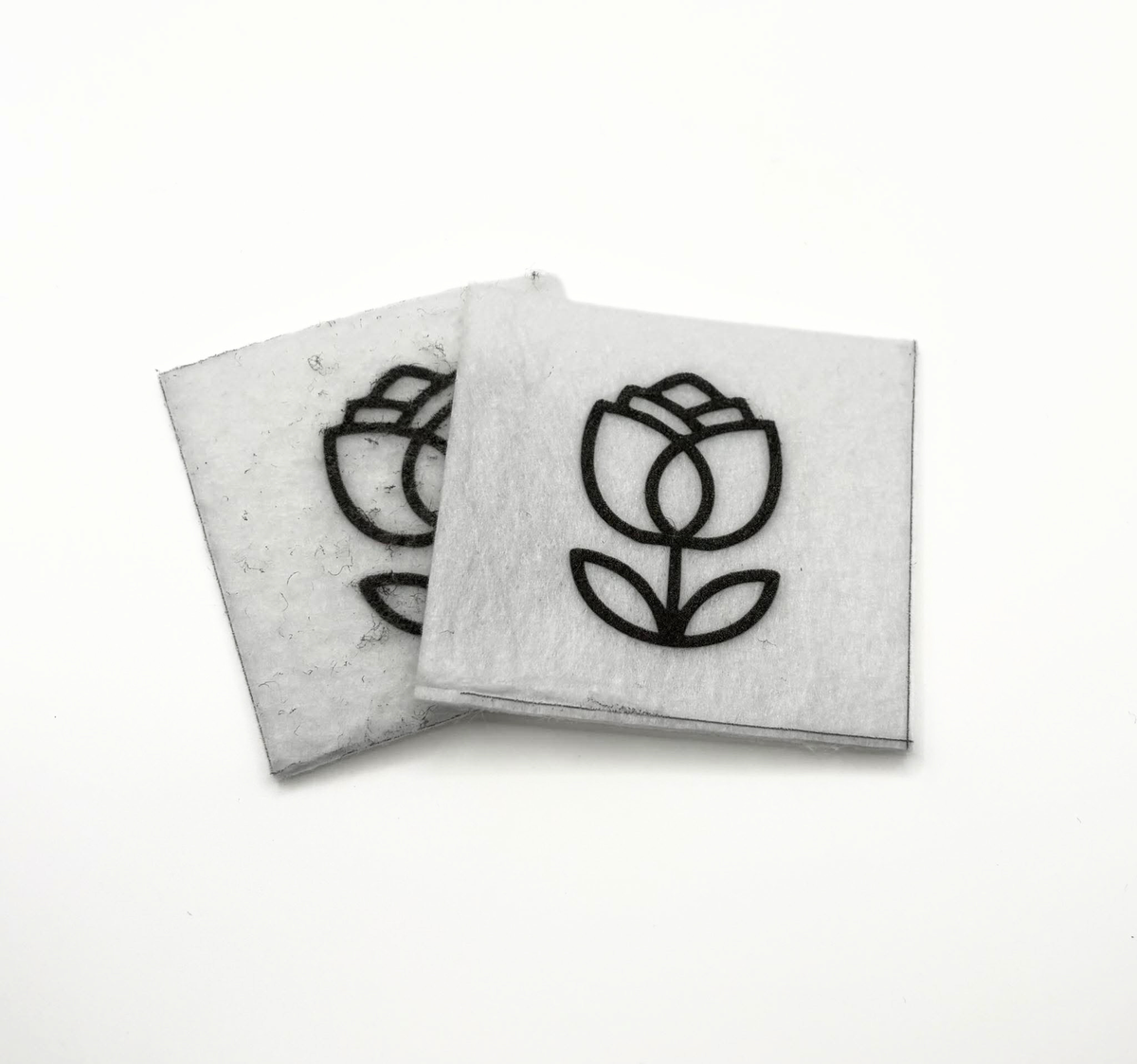 Two beading patterns printed in black on stiff white pellon squares, showing a tulip with leaves