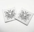 Two beading patterns printed in black on stiff white pellon squares, showing a outlined bee with layered wings