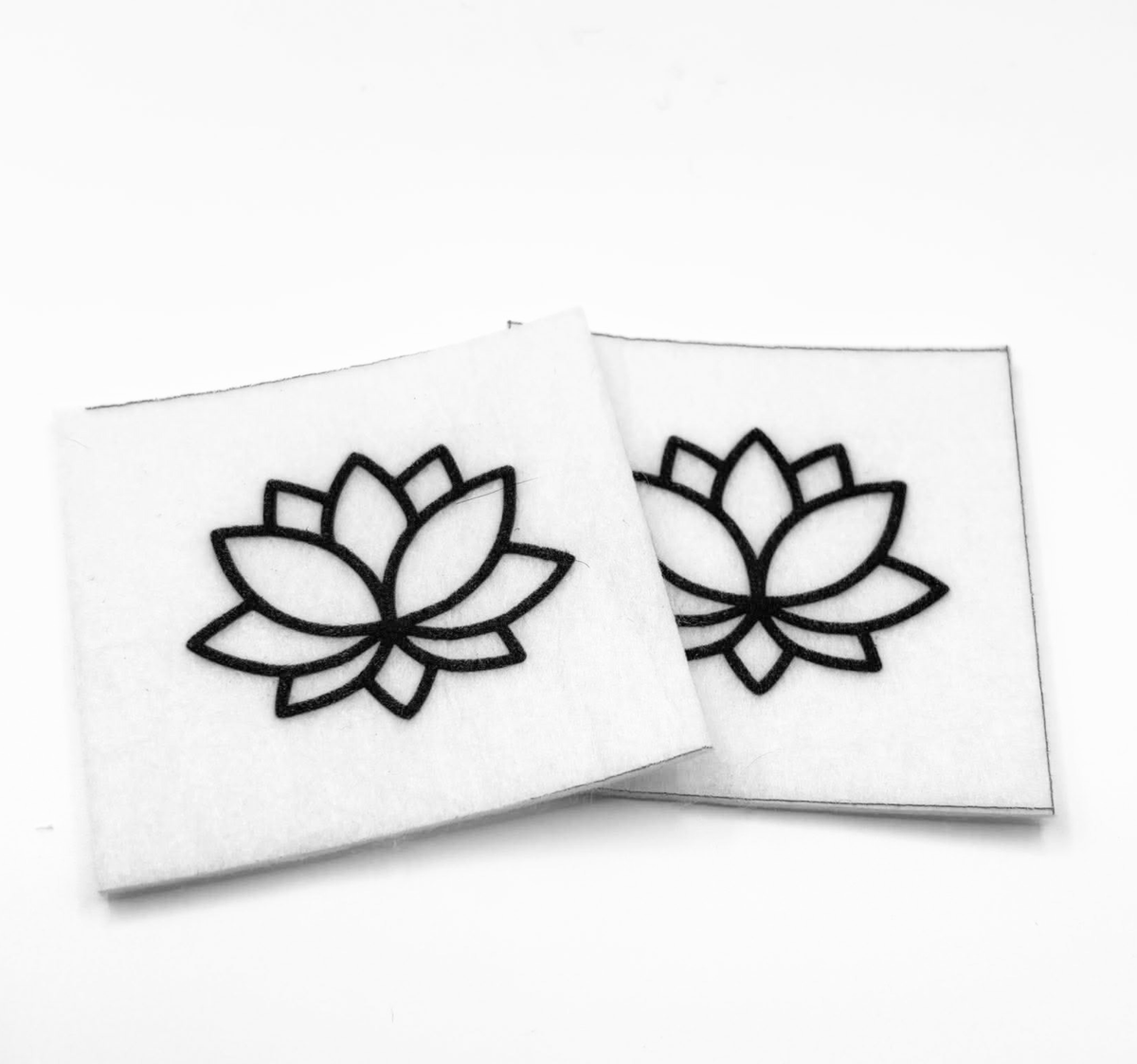 Two beading patterns printed in black on stiff white pellon squares, showing a lotus flower