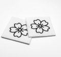 Two beading patterns printed in black on stiff white pellon squares, showing a five-petal blossom