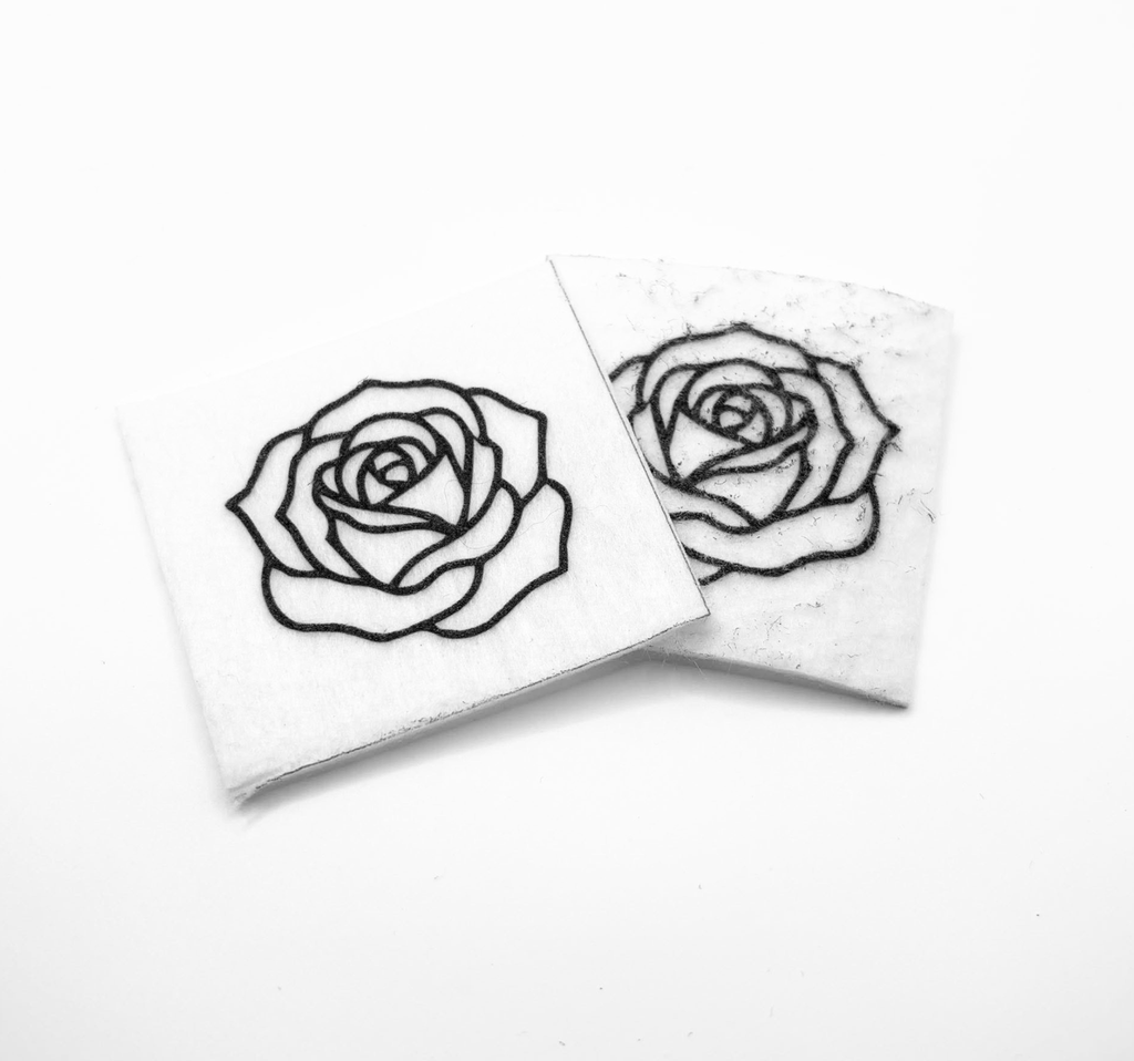 Two beading patterns printed in black on stiff white pellon squares, showing a open rose