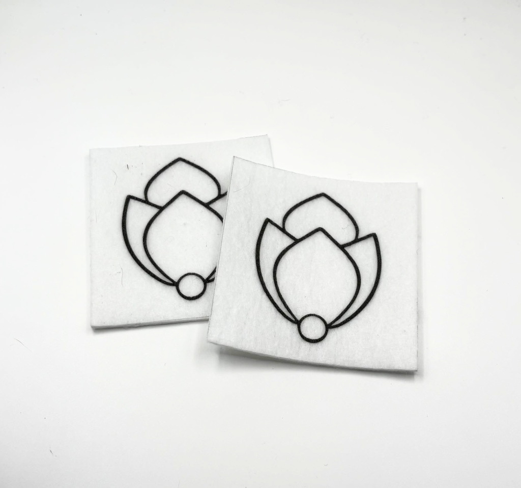 Two beading patterns printed in black on stiff white pellon squares, showing a tulip bud with a pearl