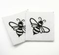 Two beading patterns printed in black on stiff white pellon squares, showing a flying bee