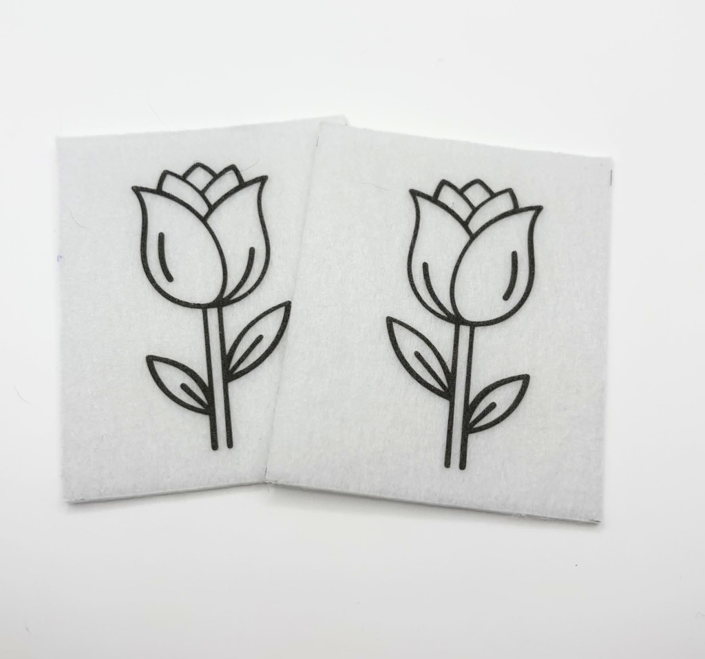 Two beading patterns printed in black on stiff white pellon squares, showing a tulip on a tall stem