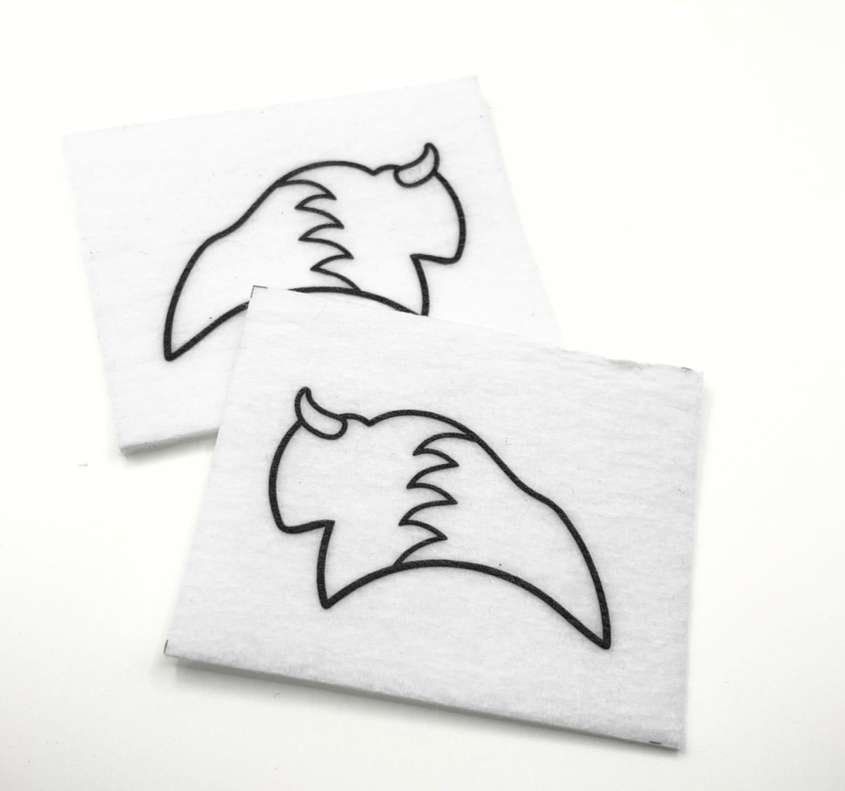 Two beading patterns printed in black on stiff white pellon squares, showing a buffalo
