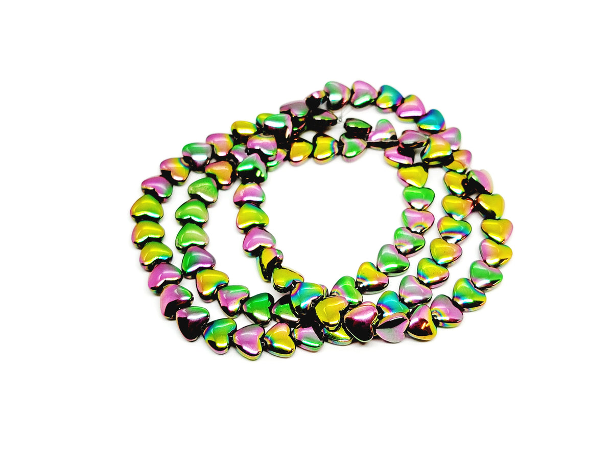 Strand of 6mm watermelon rainbow hematite heart beads coiled on a white background