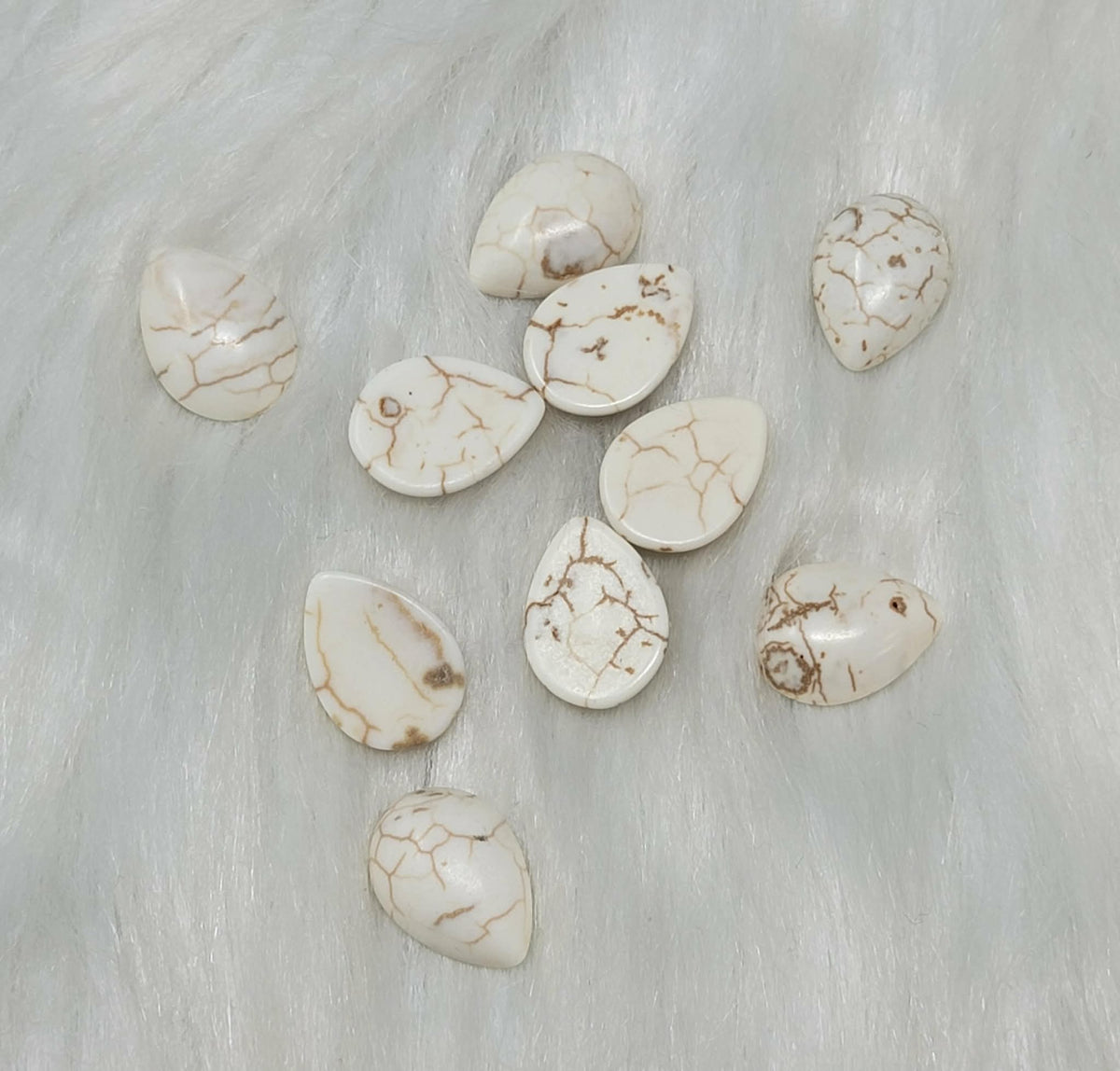 13 x 18mm dyed howlite white drop cabochons (cabs) with dark veining, on white fur