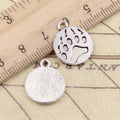 18x15mm antique silver circle bear paw charms next to a ruler