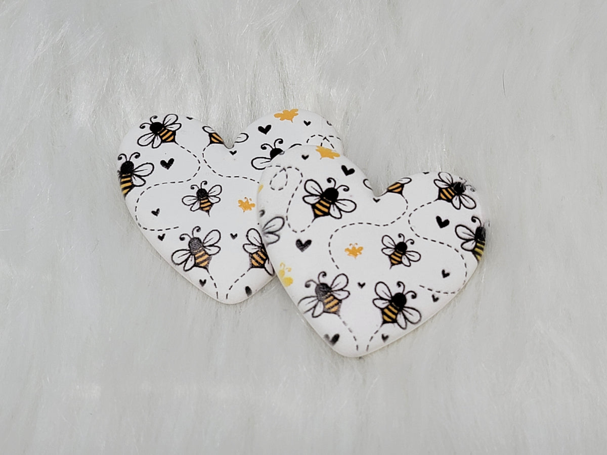 Pair of 37mm resin heart cabochons (cabs) in white with a honey bee, heart and dotted trail pattern
