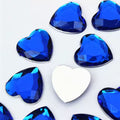 Pile of 20mm faceted blue resin heart gem cabochons (cabs), one flipped to show the flat back