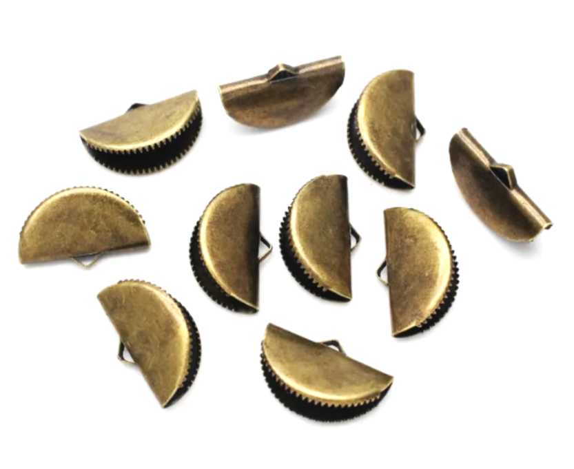 Pile of bronze pinch crimp ends in 13mm and 20mm sizes on a white background