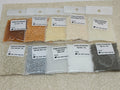 Ten 25g bags of Preciosa 11/0 seed beads in natural shades of brown, tan, cream, white, silver and grey