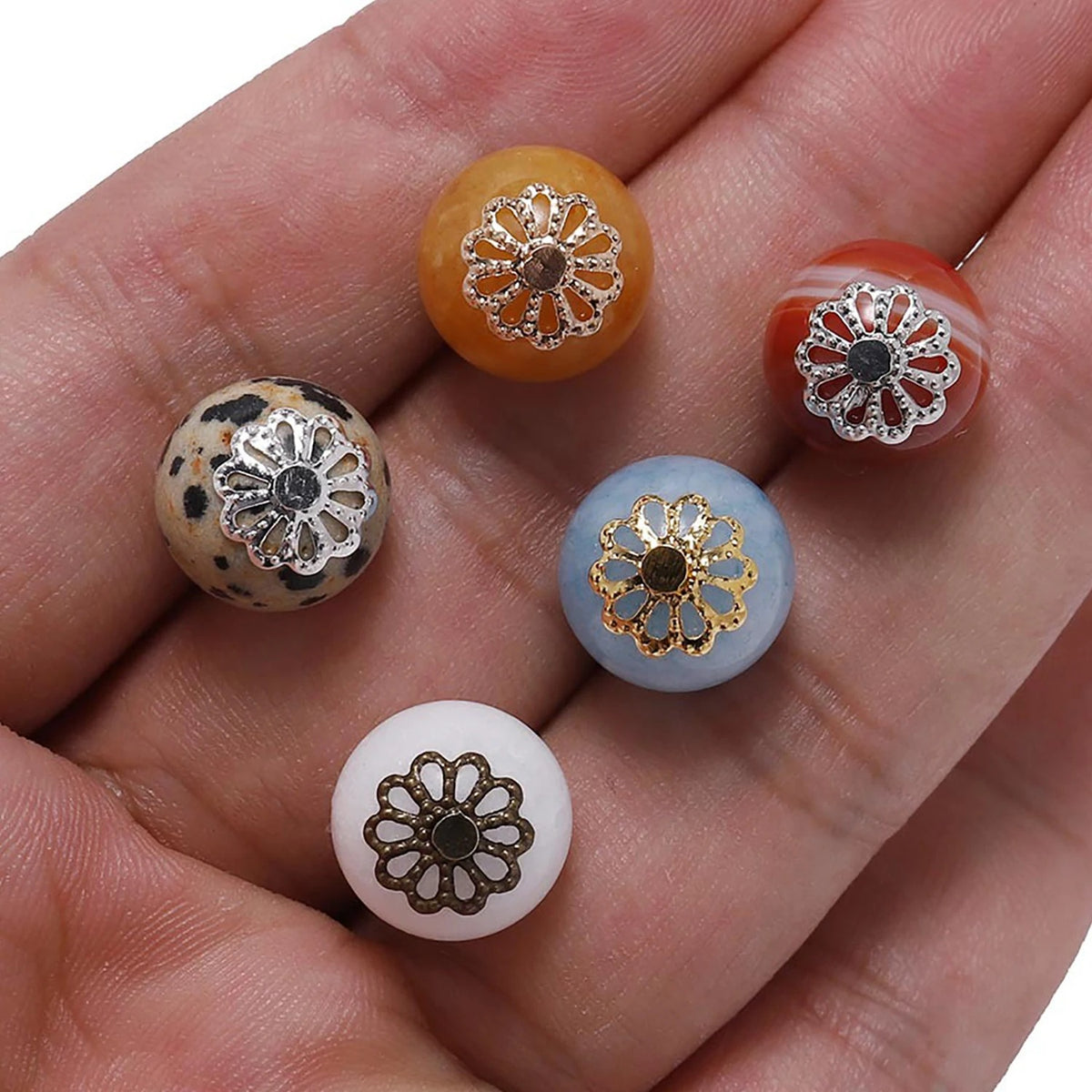assorted gold, silver and bronze filigree flower bead caps on round beads, showing scale