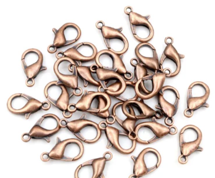 Pile of copper 6 x 12mm lobster clasps with trigger openings, on a white background