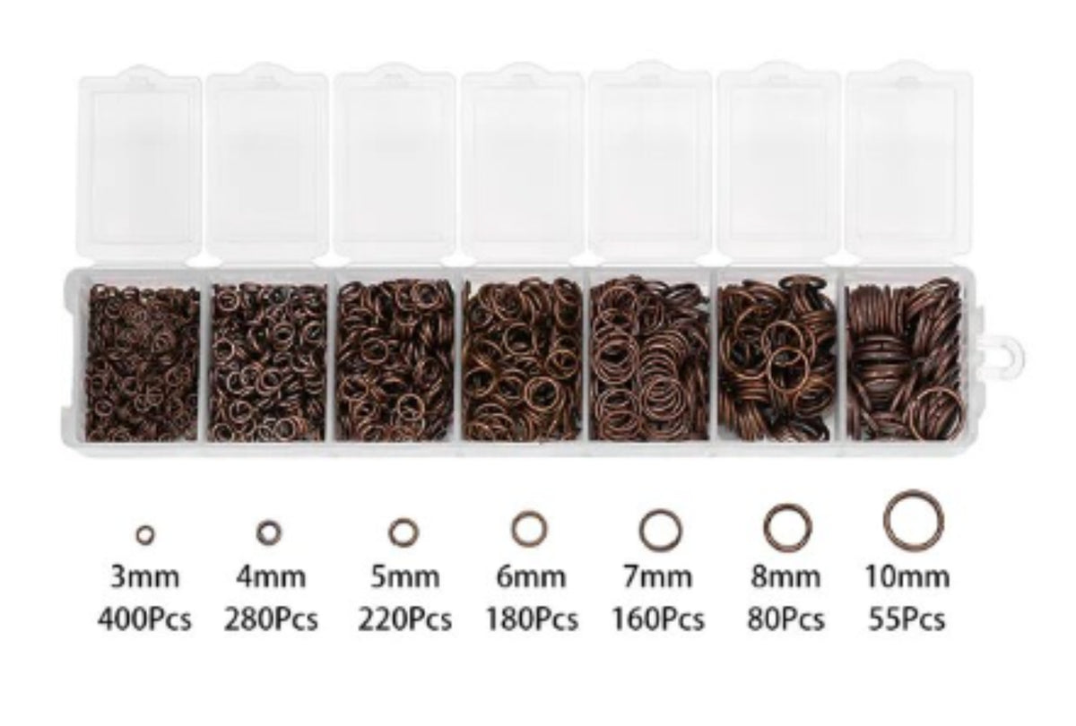 Clear divided case of copper jump rings in seven sizes from 3mm to 10mm, with size labels