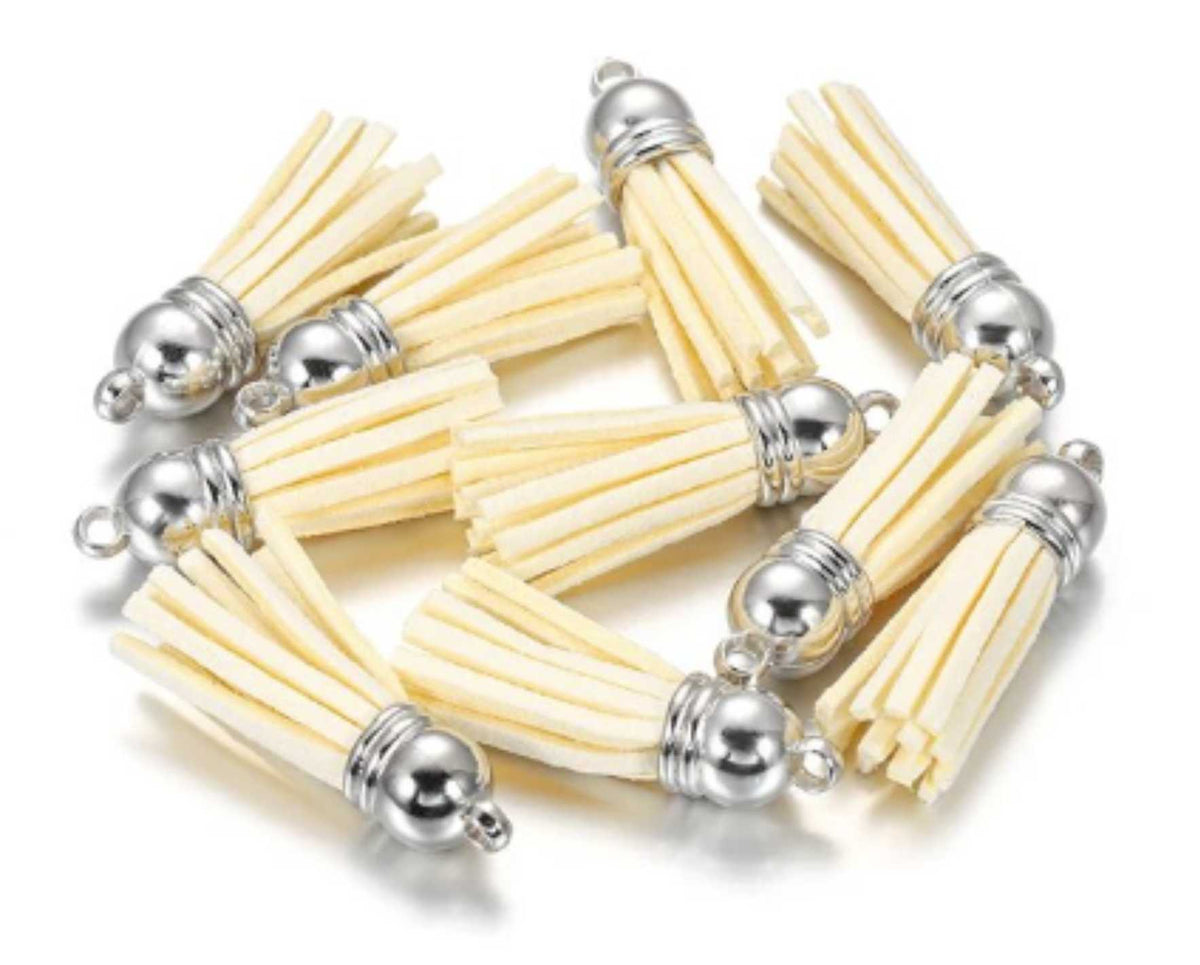 Pile of 38mm cream leather fringe tassels with silver-tone caps and loops