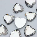 Pile of 20mm faceted crystal resin heart gem cabochons (cabs), one flipped to show the flat back