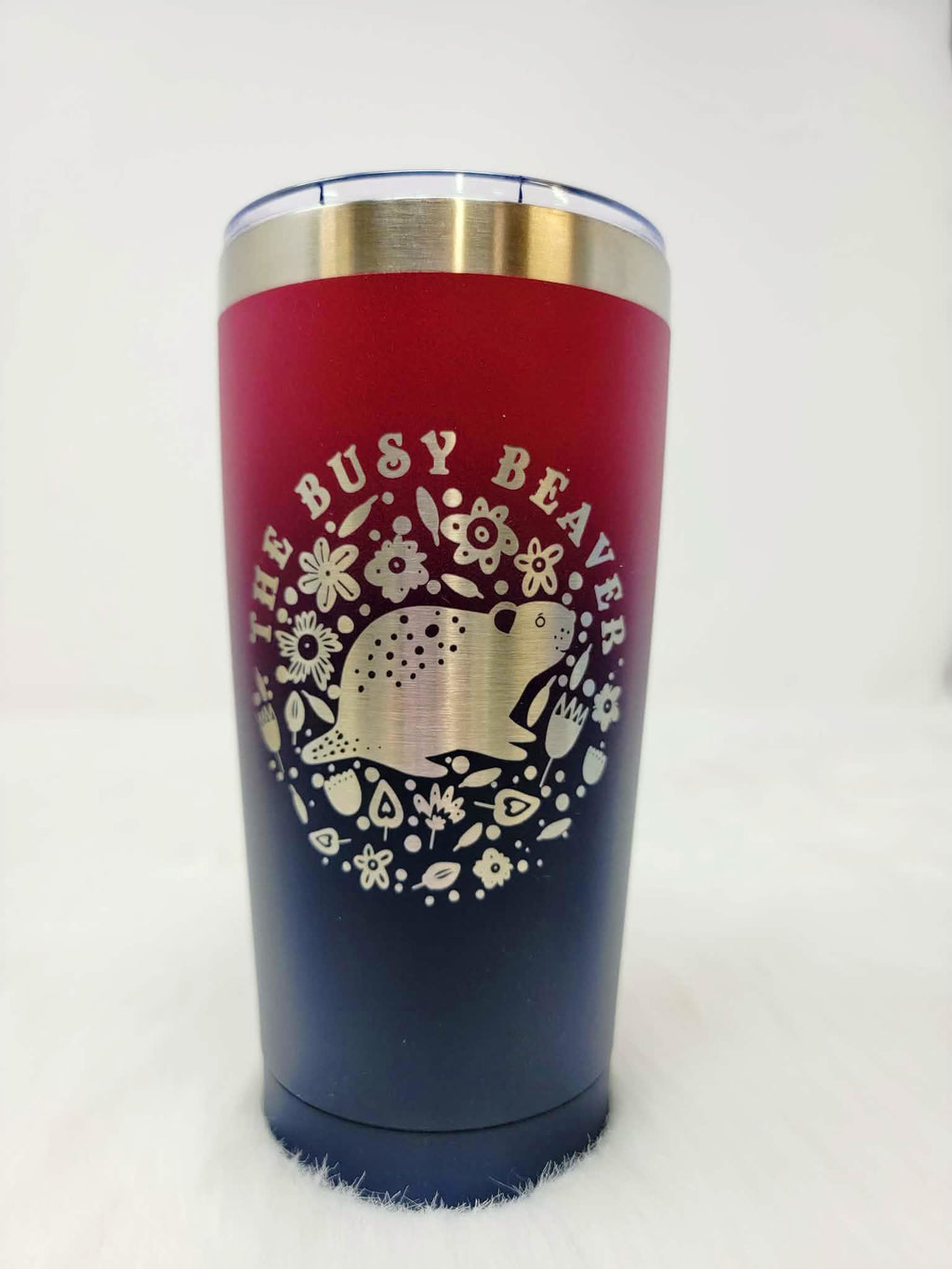 Red-to-navy fade stainless steel tumbler engraved with a round floral beaver logo