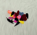 Pile of about 10 random pairs of acrylic cabochons (cabs) in glitter, marbled and solid colours