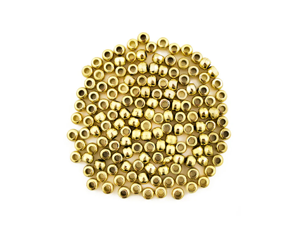 Pile of 6 x 9mm plastic pony beads in metallic gold on a white background