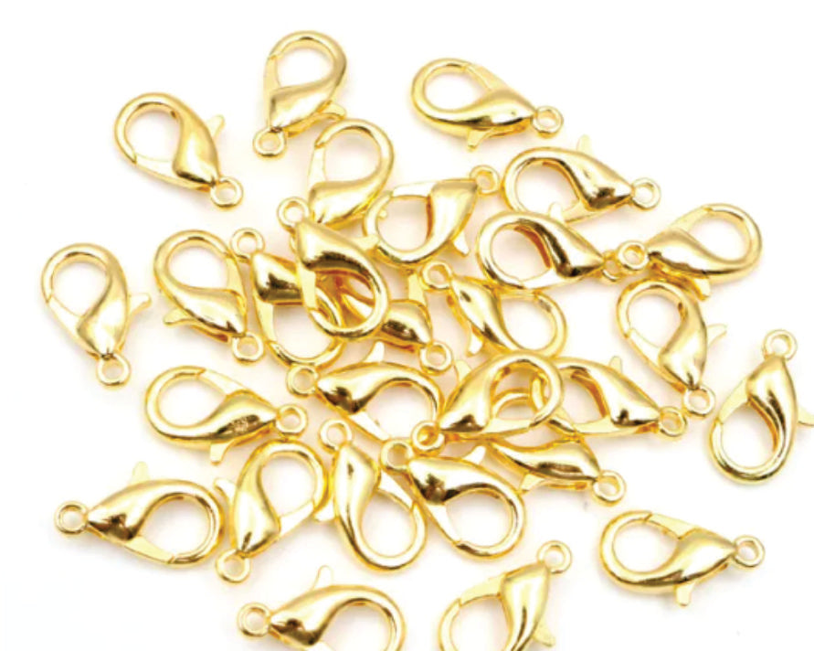 Pile of gold 6 x 12mm lobster clasps with trigger openings, on a white background