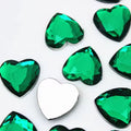 Pile of 20mm faceted green resin heart gem cabochons (cabs), one flipped to show the flat back