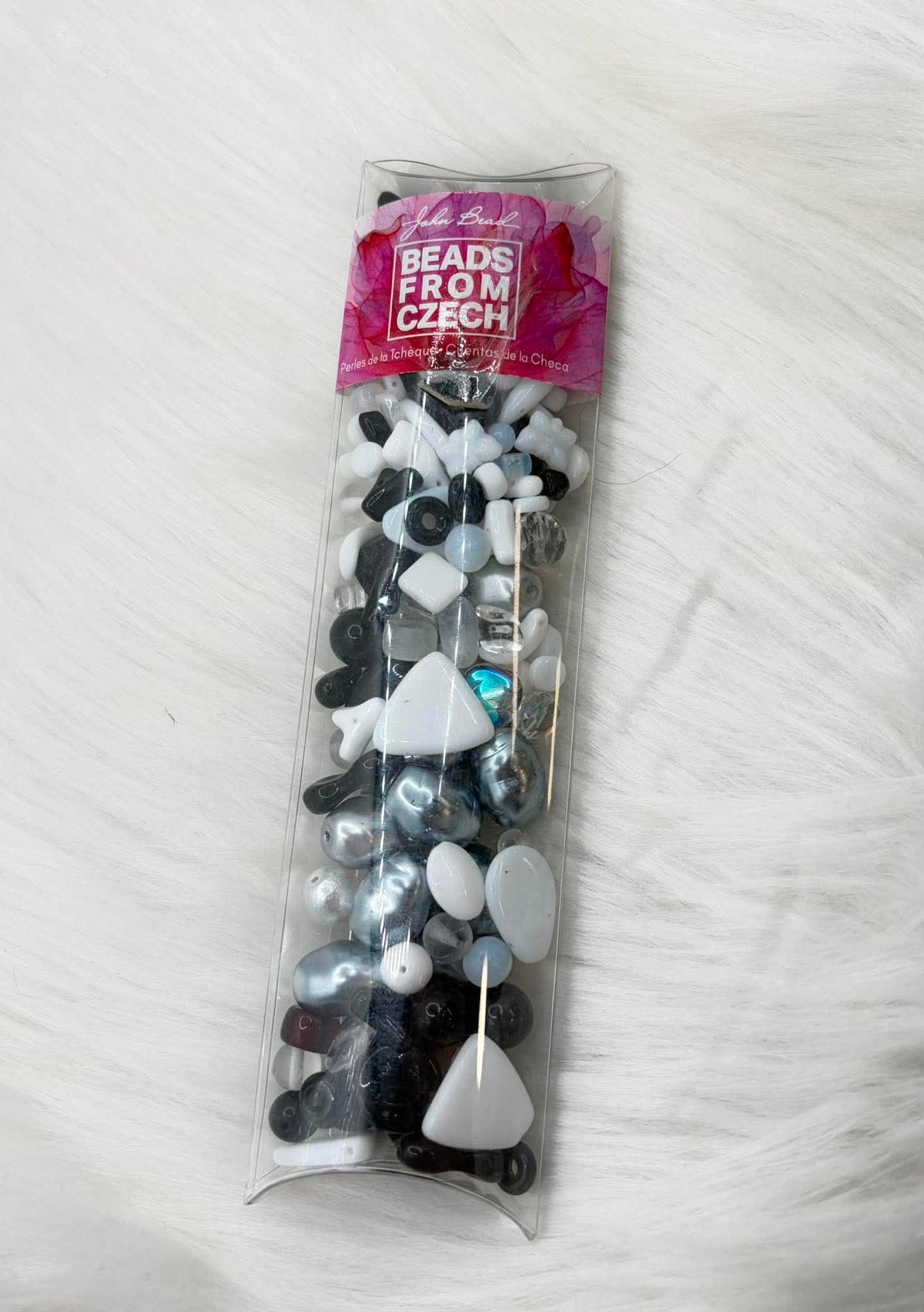 Clear bag of mixed black and white Czech glass beads in assorted shapes
